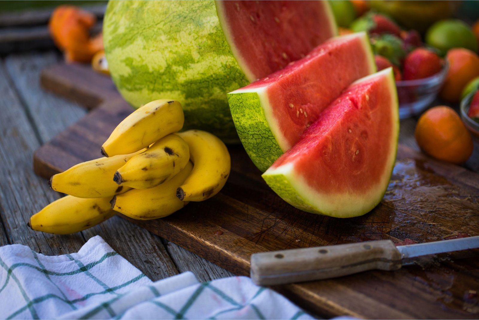 Kaliumrijke bananen liggen naast een L-citrullinerijke watermeloen op een snijplank.