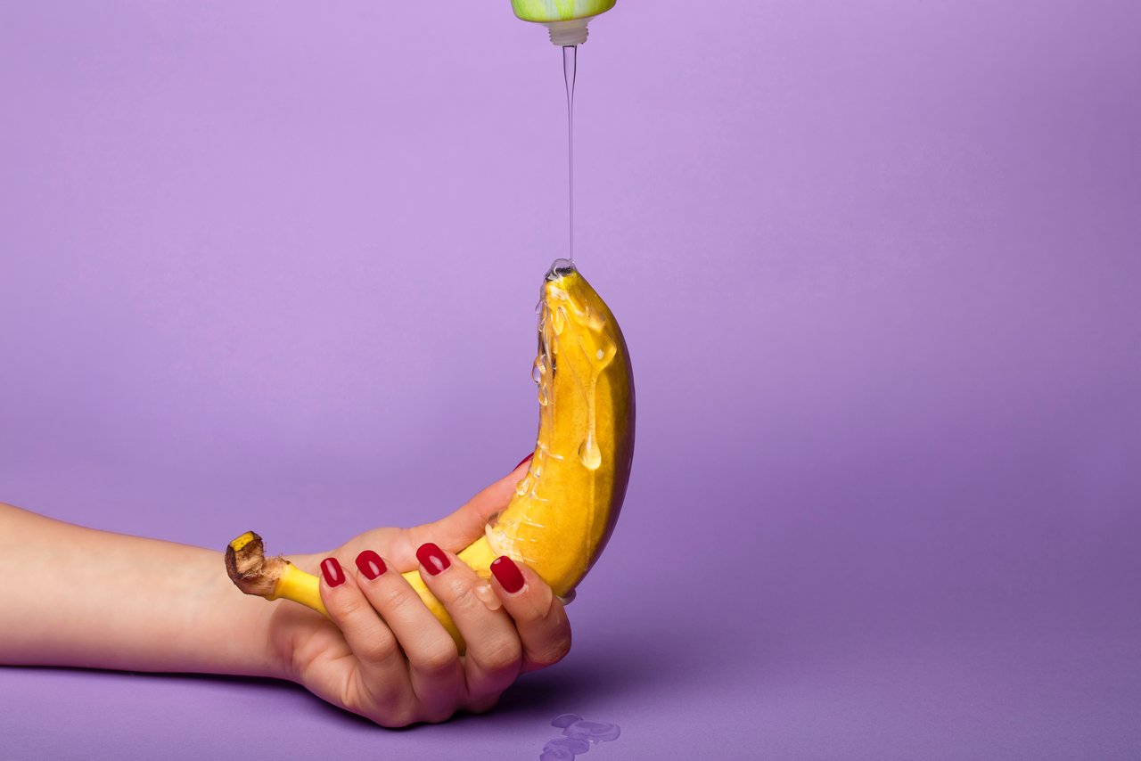 Glijmiddel wordt over een banaan geleid die met één hand wordt vastgehouden